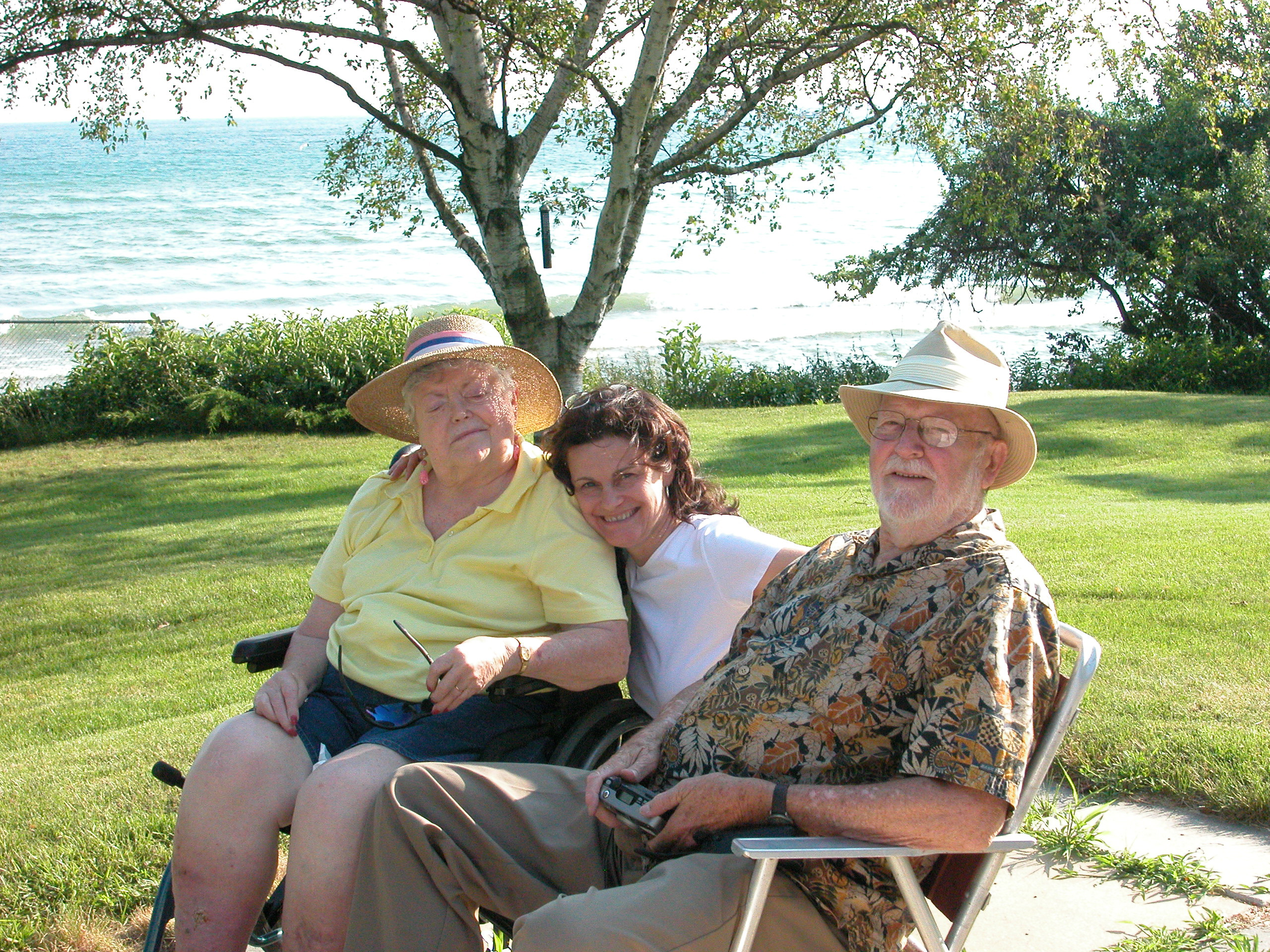 Caroline sitting on a bench with her mother and father