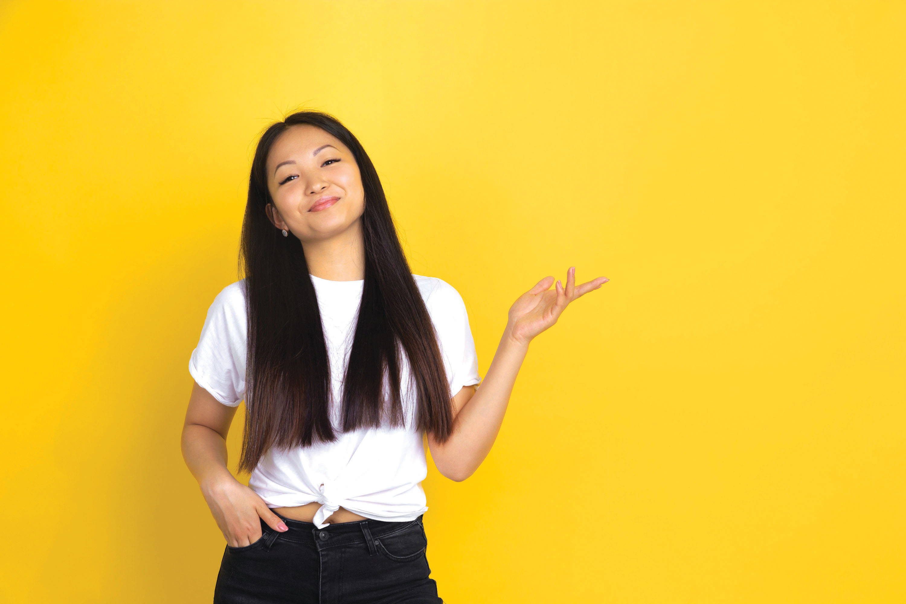 Asian female smiling with against a bright yellow background