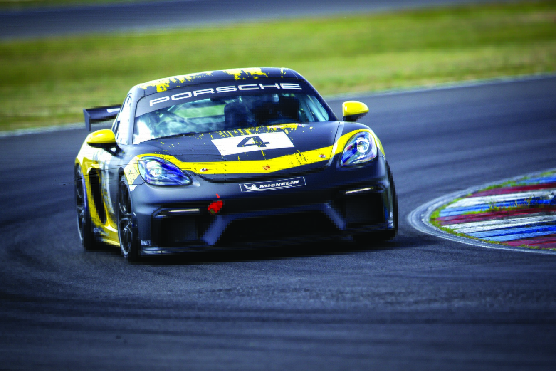 a black and yellow race car racing on the track