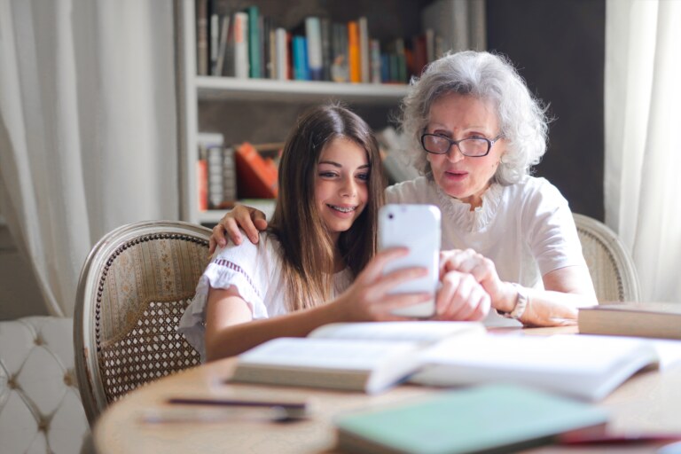 Grandchild helping her grandmother with her phone