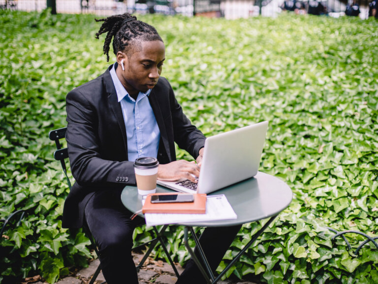 man sitting at a table on his computer