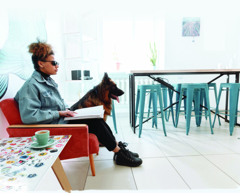 Woman sitting on couch with guide dog