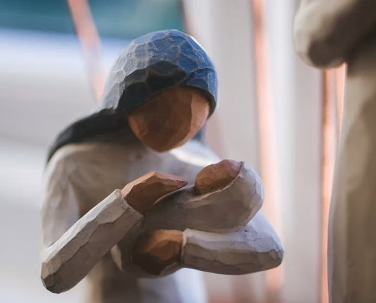 A figurine of a woman holding a swaddled baby