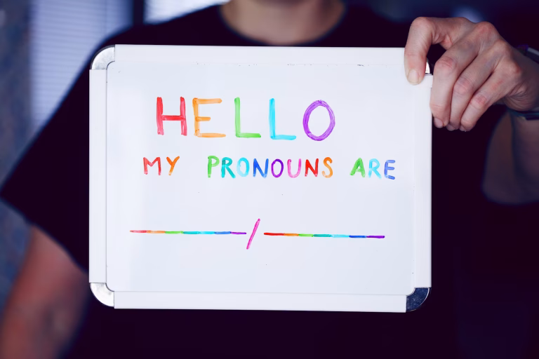 A whiteboard with rainbow text reading Hello My Pronouns are :